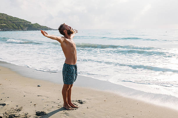 istock Man Enjoying Morning Beach with Open Arms 2229888376
