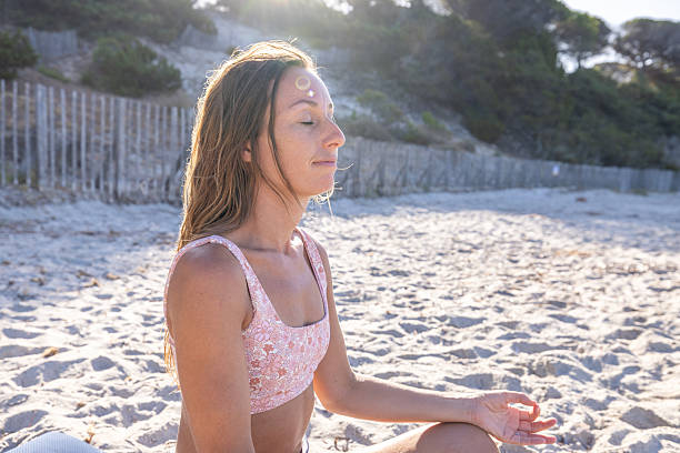 istock Woman Meditating on Sunny Sandy Beach 2229890360