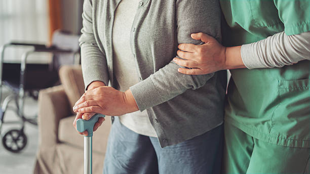 istock The nurse is helping the old patient with a cane 2229894603