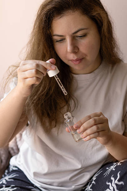istock Young Woman Holding Transparent Serum and Using Droppe 2229894959