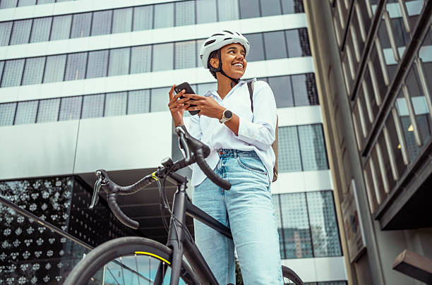 istock Young Multiracial Woman Using Smartphone While Cycling in Business District 2229897022