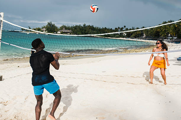 istock Couple Serving Volleyball on Beach 2229898241