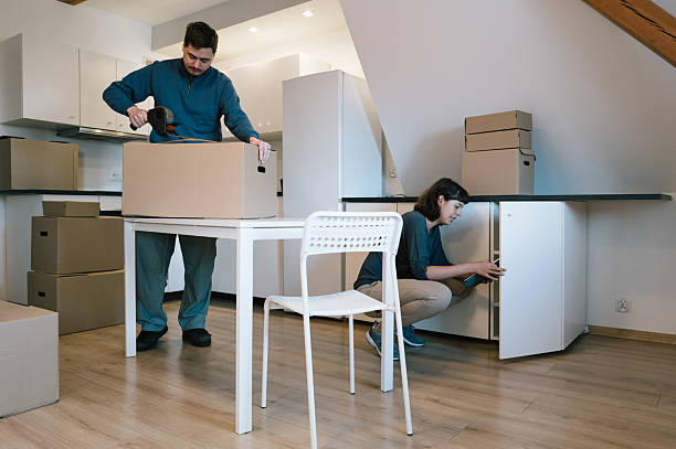 istock Relocation: A young woman checks the kitchen cabinets with a touchpad while a man packs boxes 2229900652