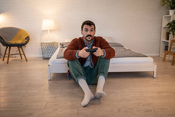 istock Young man playing videogames at home in his bedroom 2229902197