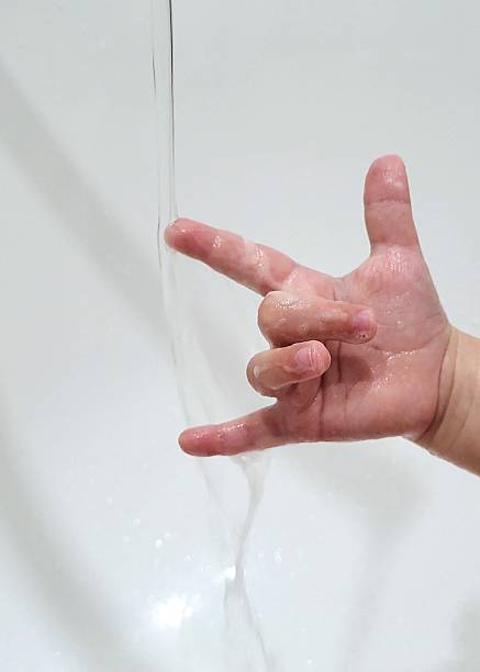 Funny Gesture: Child's Hand Under a Stream of Water