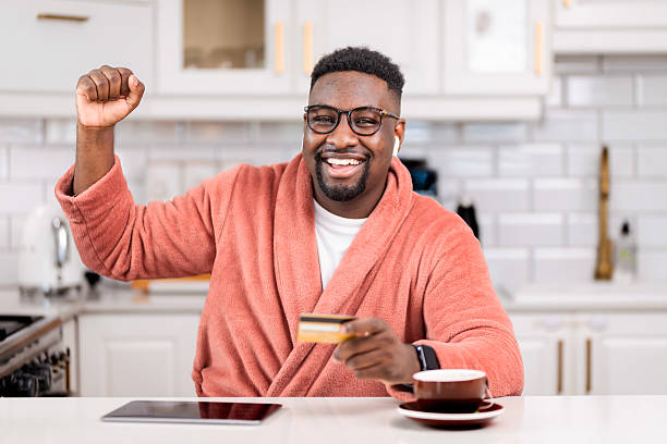 istock Happy Man in Bathrobe Shopping Online in a Modern Kitchen 2229903357