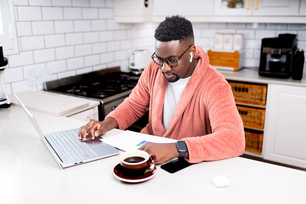 istock Man Working From Home in Casual Attire With Coffee and Laptop 2229903385