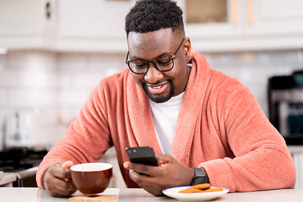istock Man in Relaxed Morning Routine Enjoying Coffee and Smartphone Browsing 2229903395