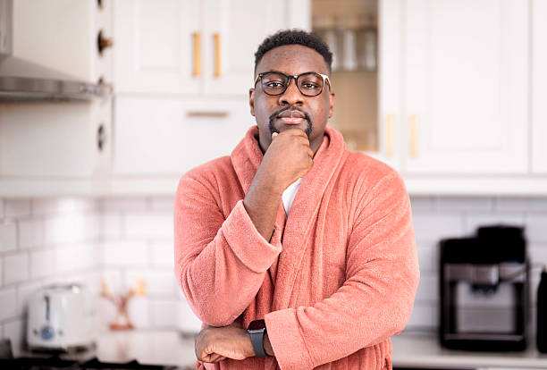 Confident Man in a Cozy Home Kitchen Wearing Reading Glasses and Warm Bathrobe