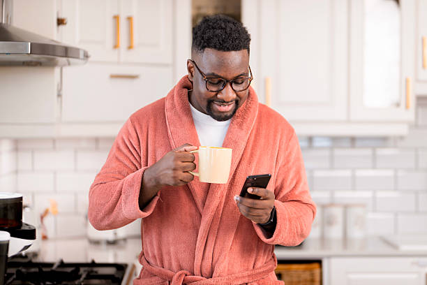 istock Man in Orange Robe Saving Morning Reading His Smartphone 2229903407