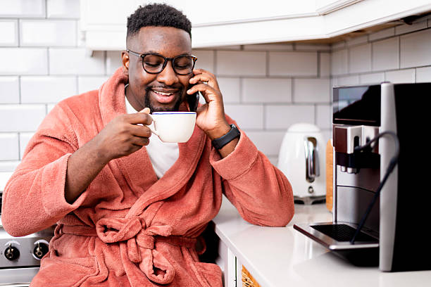 istock Man Enjoys Coffee and Phone Call in Cozy Kitchen Setting 2229903424