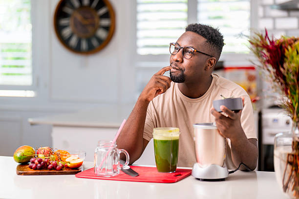 istock Person Contemplating While Making a Fresh Green Smoothie in the Kitchen 2229903815