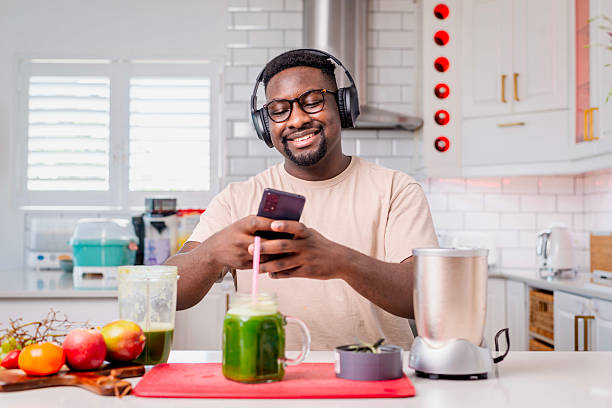 istock Man Enjoying Smoothie Creation While Using Phone and Listening to Music 2229903821