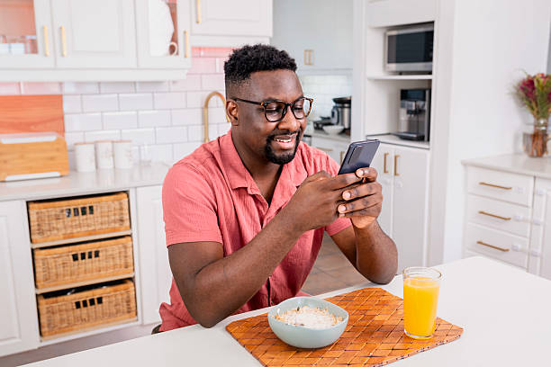 istock Man Enjoying Breakfast and Smartphone in Bright Modern Kitchen Setting 2229903979