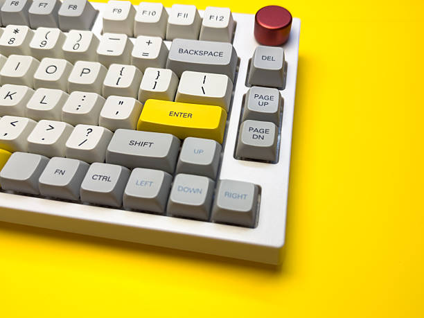 istock White mechanical keyboard with bright Enter key on bright yellow background, minimalism, keyboard buttons. A keyboard with a yellow key on the bottom left 2229904964