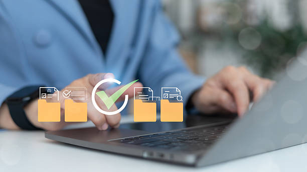 istock Businesswoman using a laptop to manage digital document folders with approval checkmark icons on a virtual screen, concept of data organization and verification 2229913525