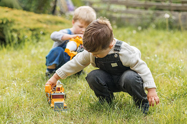 istock Two little boys playing with toy trucks outside 2229914000
