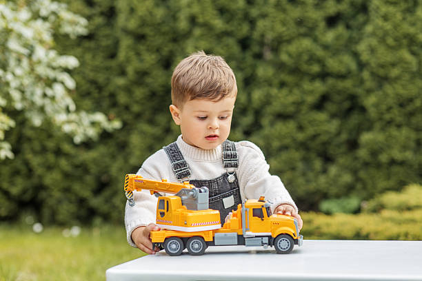Young boy with autism and ADHD has fun watching the activities of the construction workers on the street.