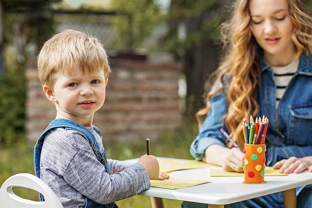 istock Little boy drawing with colored pencils outdoors 2229915075