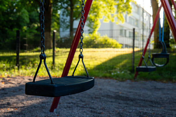 istock Empty Playground Swings on a Sunny Day Outside 2229916747