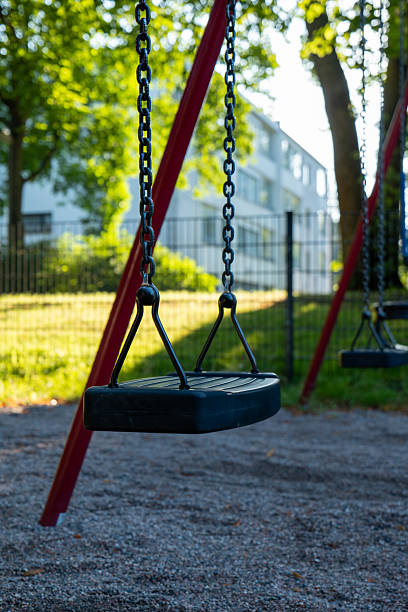 istock Empty Swings in a Sunny Park on a Summer Day 2229916748
