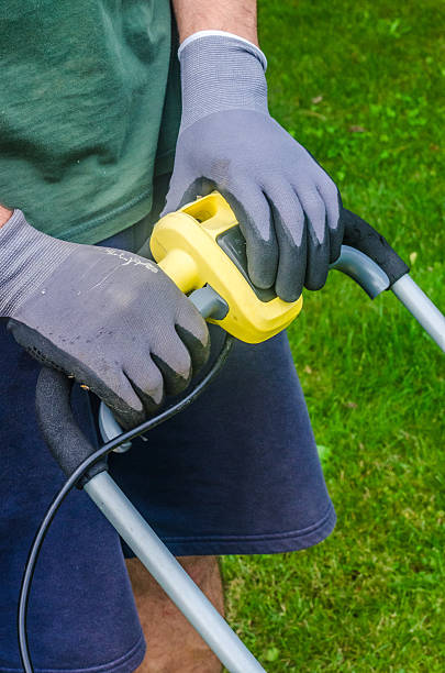 istock Hands in Gloves Operating Lawn Mower Handle 2229917646