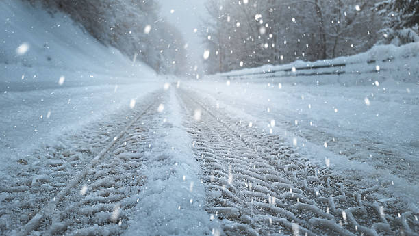 Snow-Covered Road with Tire Tracks During Snowfall