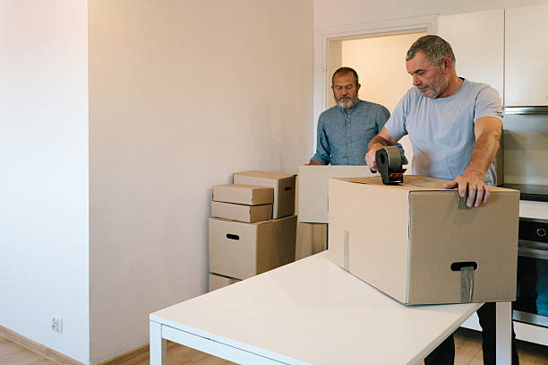istock Moving: two elderly men carry boxes in the kitchen of an empty apartment 2229921306