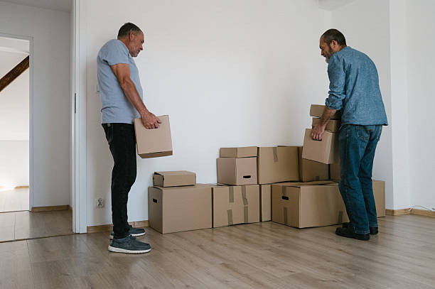 istock Moving: two elderly men stacking boxes in the room of an empty apartment 2229921344