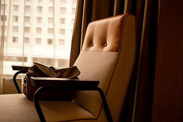 Close-up shot of Modern Wood Lounge Chair With Cushion in Bedroom. concept: Tropical modern bedroom,\nSimple wooden chair,\nBedroom furniture,\nTropical decor bedroom,\nModern minimalist design