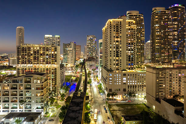 istock Elevated train system through Brickell district in Miami, Florida with city skyscrapers illuminated public transportation network 2229925285