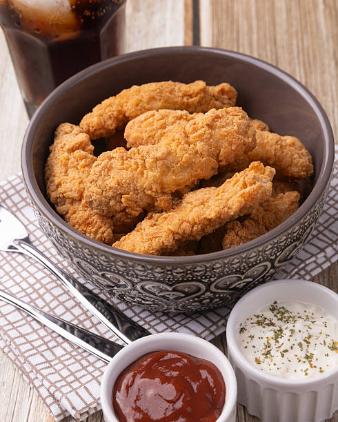 istock Breaded chicken bites in a plate over wooden table 2229927872