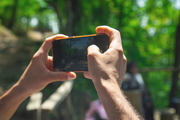 Man taking picture in nature by smartphone.