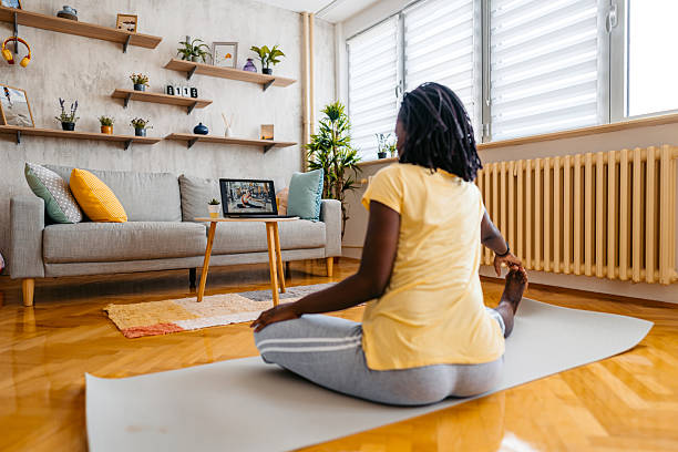 istock Mid-Adult Black Woman Watching A Tutorial On A Laptop While Stretching At Home 2229931744