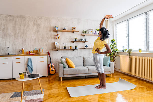 istock Mid-Adult Black Woman Watching A Tutorial On A Laptop While Stretching At Home 2229933352