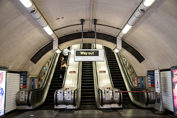 Way Out sign on the London Underground with escalator in the background, symbolising exit, travel direction, and iconic UK transport design.