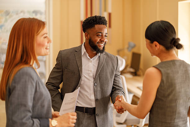 istock Businessman smiling and welcoming female professionals with handshake before a collaborative planning session. 2229943689