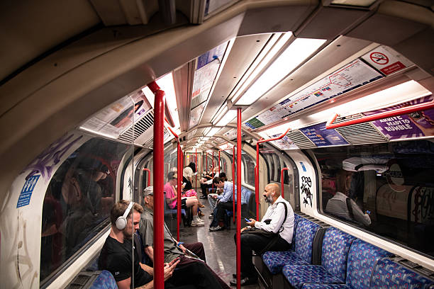Interior of a Central Line London Underground train, showing seating, grab poles, and passengers commuting through the capital's iconic Tube network.