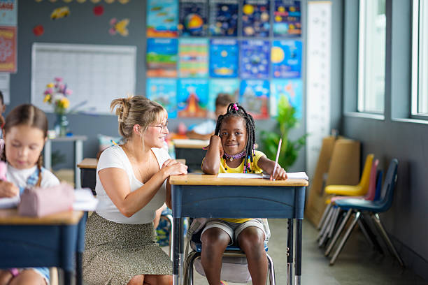 istock Teacher and Student Interacting in a Colorful Classroom Setting 2229948384