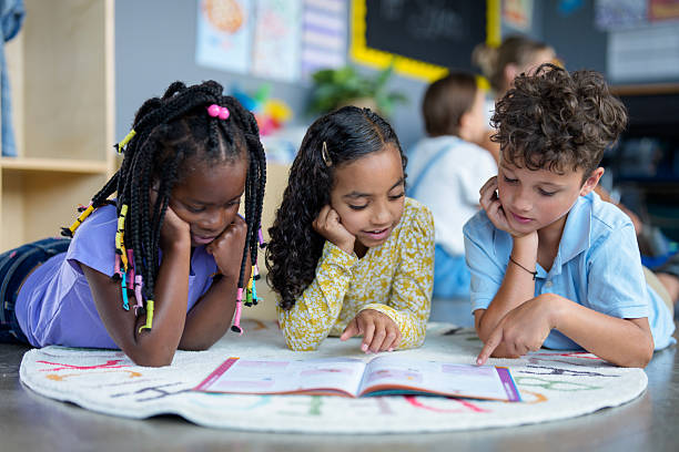 istock Three Diverse Children Reading Together on Classroom Floor During Lesson 2229949075