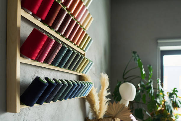 istock Colorful Spools of Thread Arranged on Wall Shelf in Bright Sewing Studio 2229949121