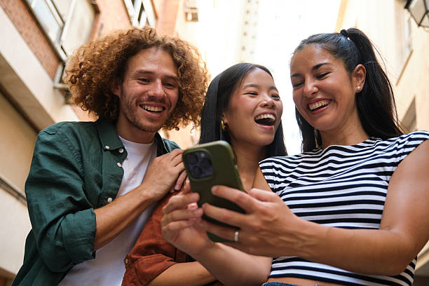 istock Happy friends having fun using a mobile phone outdoors 2229949291