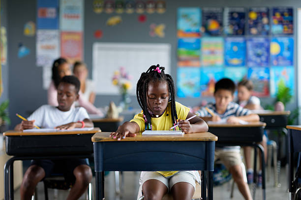 istock Focused Students Writing in a Vibrant Classroom Environment 2229950539