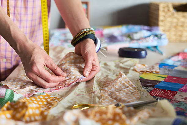 istock Caucasian Woman Sewing Patchwork Quilt with Hands Carefully Arranging Fabric 2229956352