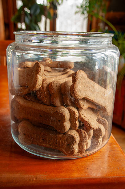 istock Bone-shaped dog biscuits in an open glass jar on a wooden table 2229962851
