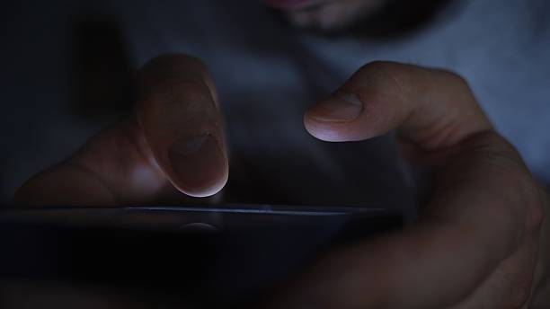 istock Smartphone and social network addiction concept. Hands using smartphone in bed at night 2229962904