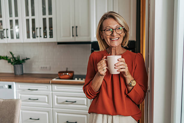 istock Smiling senior woman drinking tea in a modern kitchen 2229967144