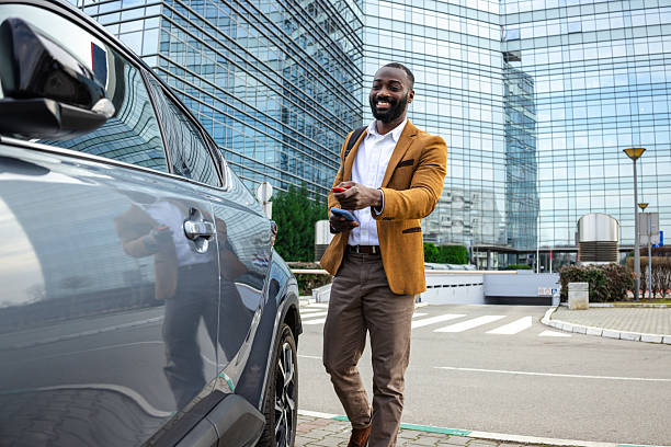istock Businessman unlocking his car outside a modern glass office building 2229973049