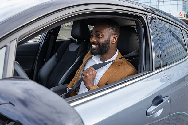 istock Smiling man fastening seatbelt inside a modern vehicle for safe driving 2229973061