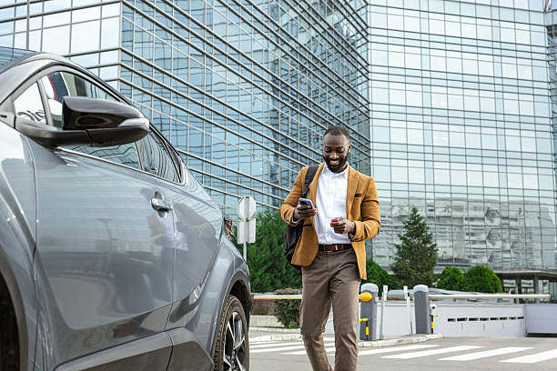 istock Businessman unlocking his car outside a modern glass office building 2229973474